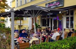 Menschen genießen Kaffee und Gespräche im Freien vor dem Schlosscafe in Potsdam.
