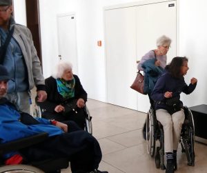 Eine Gruppe von Menschen in Rollstühlen trifft sich im Humboldtforum.